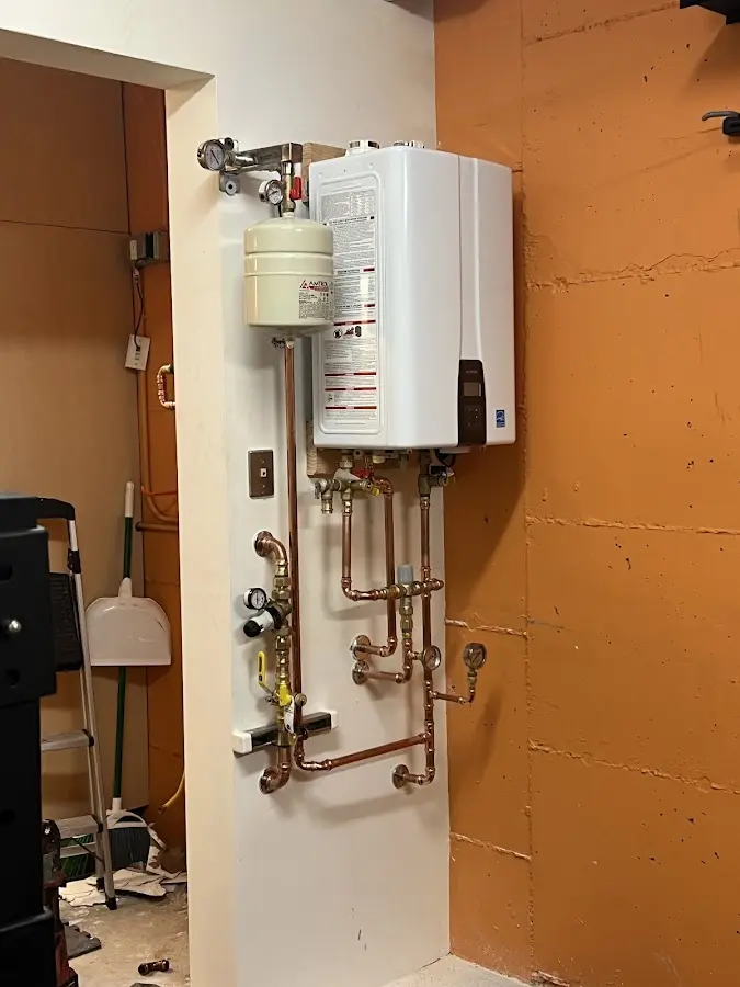 Plumbing technician inspecting water heater connections in Flowing Wells